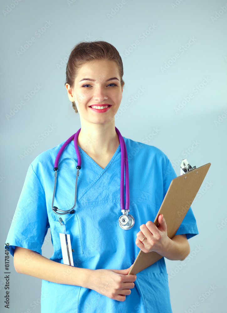 Smiling female doctor with a folder in uniform standing at