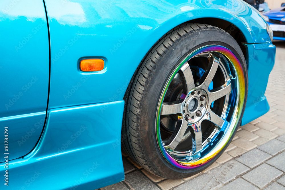  Car wheel on colorful metallic disc, closeup photo