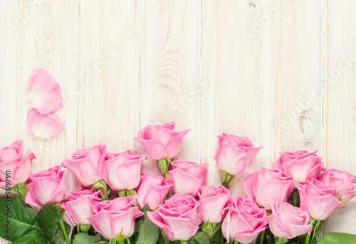 Pink roses bouquet over wooden table