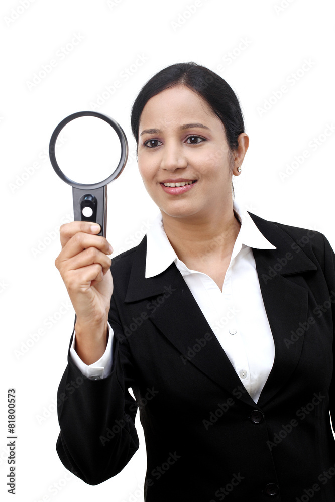 Young businesswoman looking through a magnifying glass Young businesswoman looking through a magnifying glass