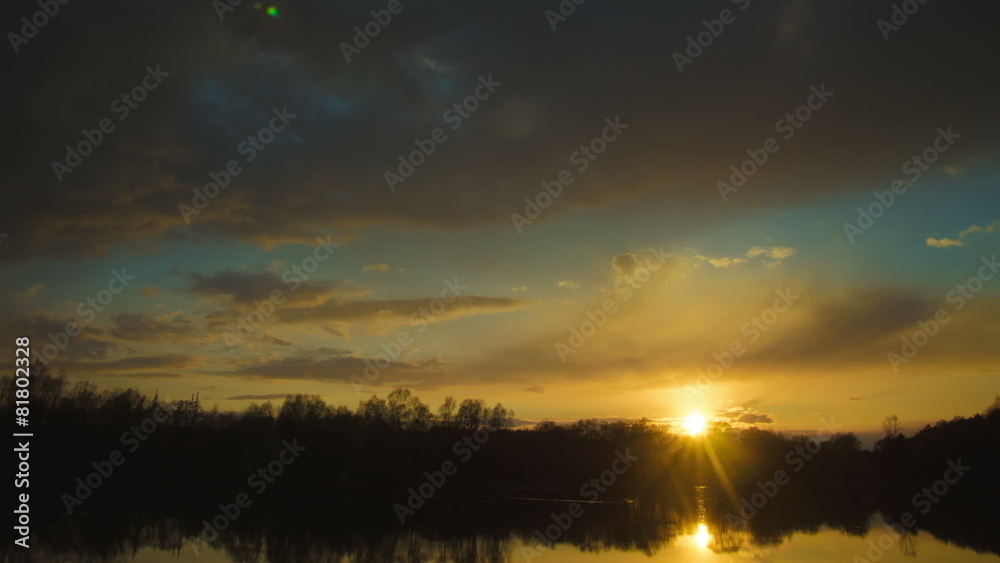 The picturesque sunset (sunrise) above forest near the lake The picturesque sunset (sunrise) above forest near the lake