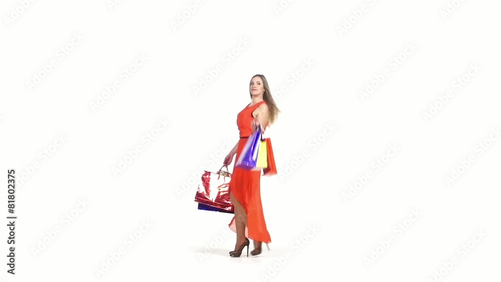 Smiling, beautiful, blonde girl in red dress with shopping bags Smiling, beautiful, blonde girl in red dress with shopping bags