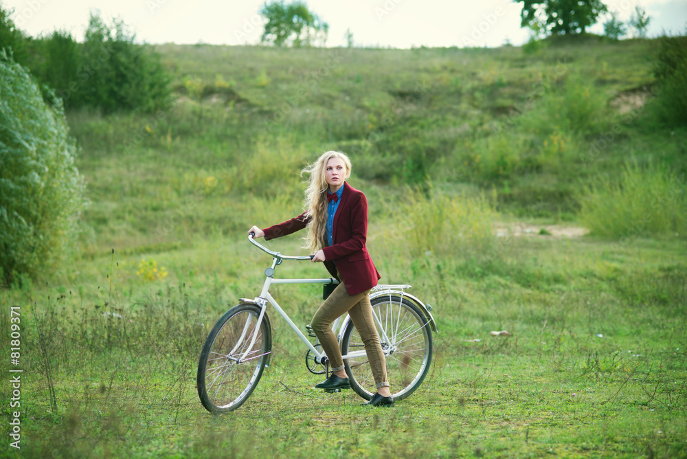 The beautiful blonde on a bicycle in the spring