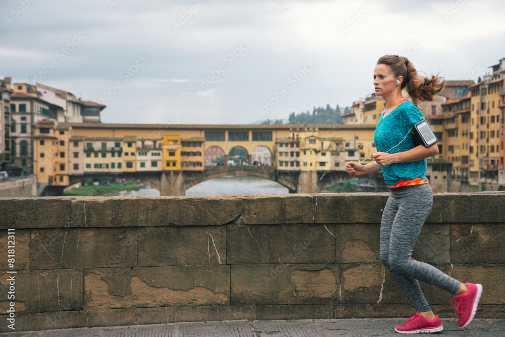 Fitness woman jogging in front of ponte vecchio in florence