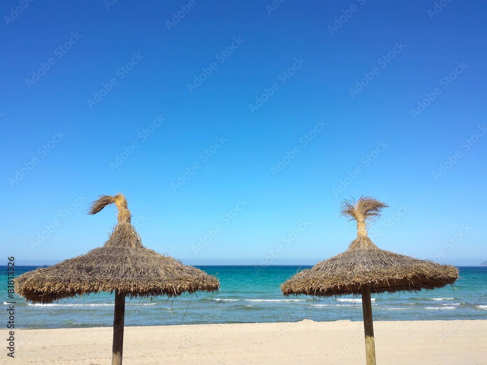 Deux parasols en paille sur la plage
