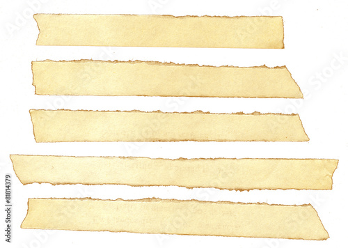 A collection of isolated torn pieces of old yellow paper