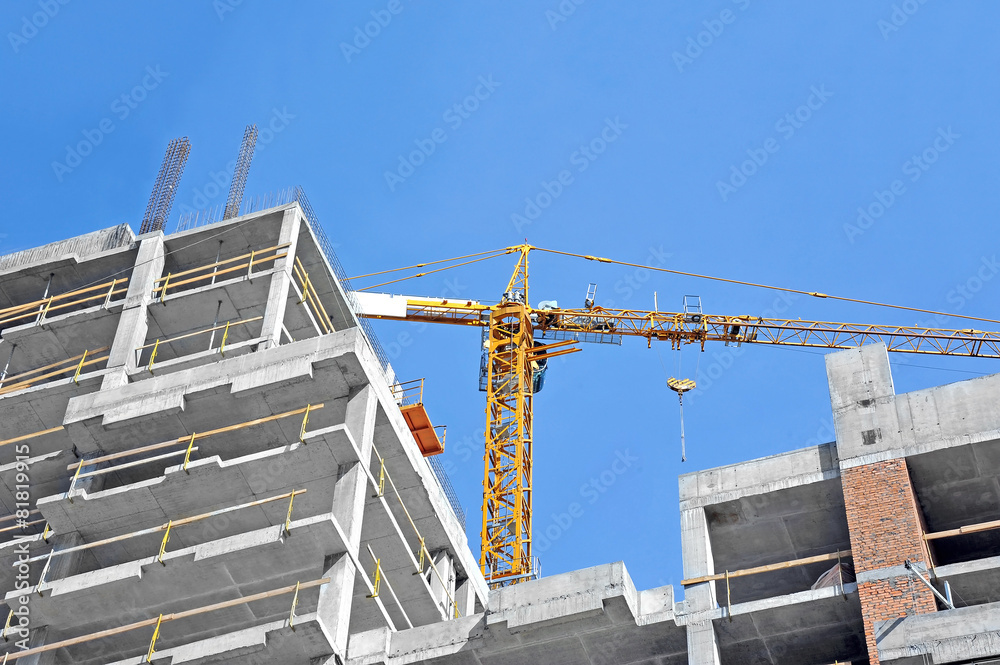 Crane and building construction site against blue sky Crane and building construction site against blue sky