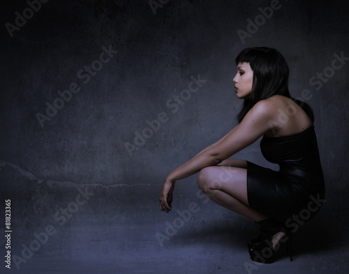 girl in a profile side squatting and looking