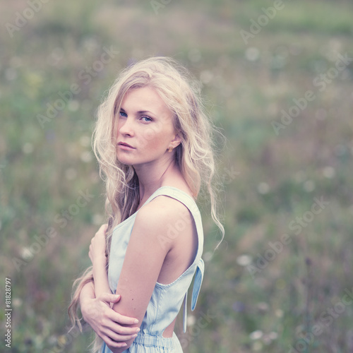 portrait of a beautiful blonde in a field in spring
