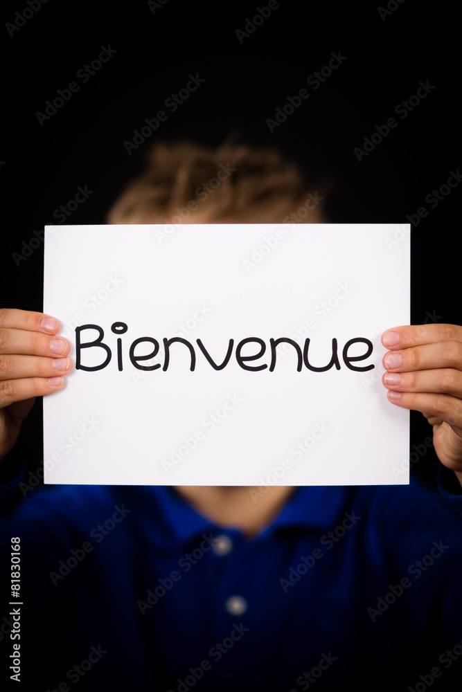 Child holding sign with French word Bienvenue - Welcome Child holding sign with French word Bienvenue - Welcome