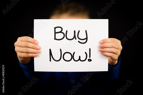 Child holding Buy Now sign