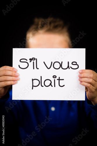 Child holding sign with French words S il Vous Plait - Please