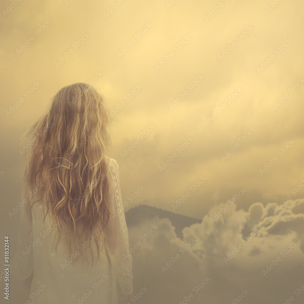 girl in a dress stands in the clouds over the mountains - obrazy, fototapety, plakaty 