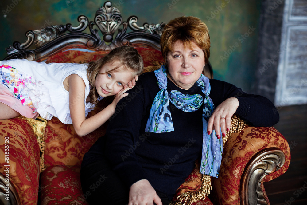 Portrait Of Grandmother With Granddaughter Relaxing Together On Sofa