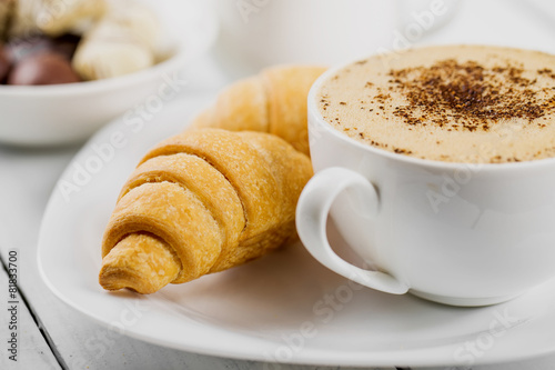 Fototapeta Naklejka Na Ścianę i Meble -  Hot cappuccino and pastries on white wooden boards