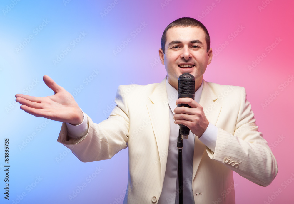 Man in white suit with microphone. Vivid emotions. Colored back Man in white suit with microphone. Vivid emotions. Colored back