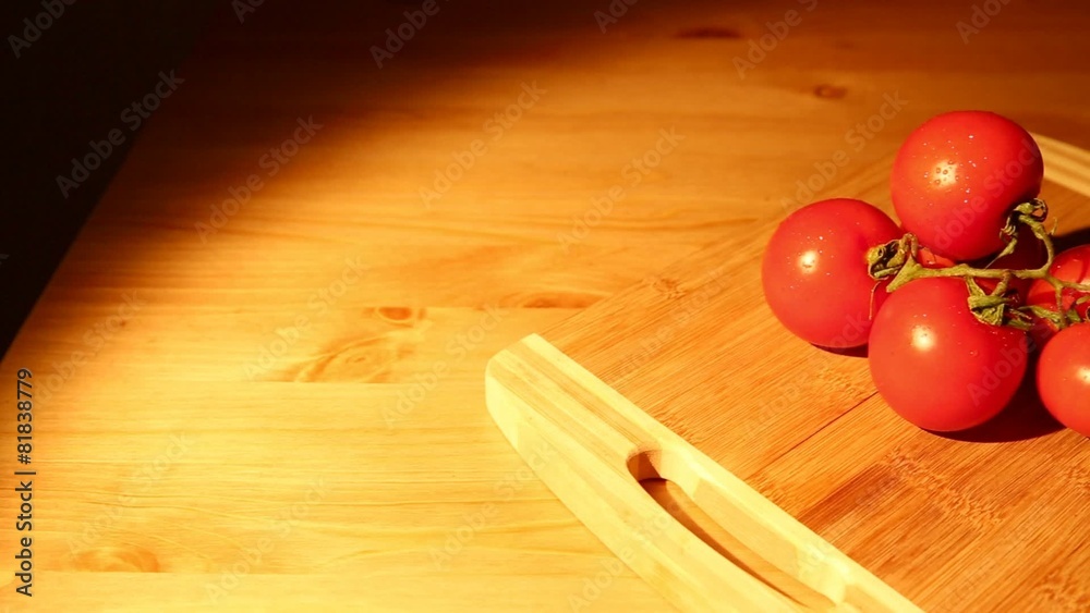 A bunch of tomatoes on a cutting board sliding dolly shot