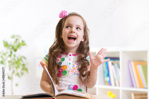 smiling child girl reading ...