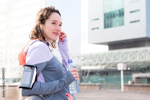 Young attractive woman adjust her music player before running