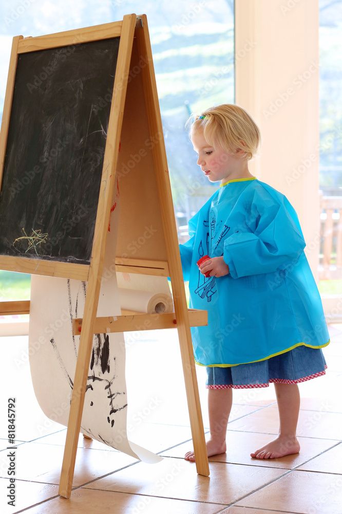 Obraz premium Cute preschooler girl drawing or painting indoors