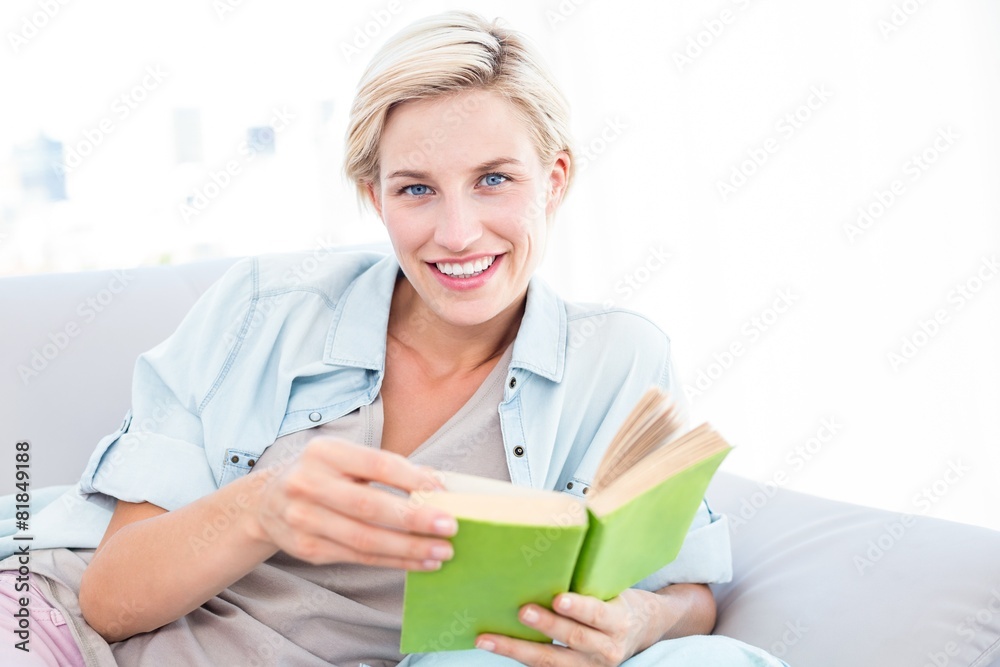 Pretty blonde woman reading a book on the couch Pretty blonde woman reading a book on the couch