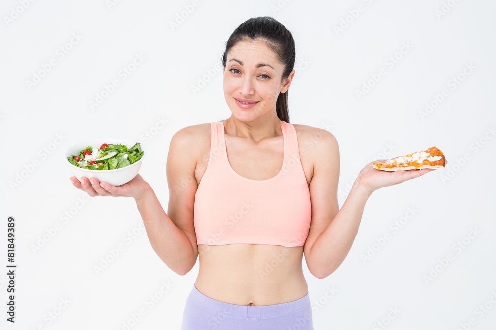 Pretty brunette holding pizza and salad Pretty brunette holding pizza and salad