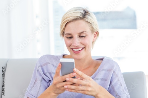 Pretty blonde woman texting with her mobile phone