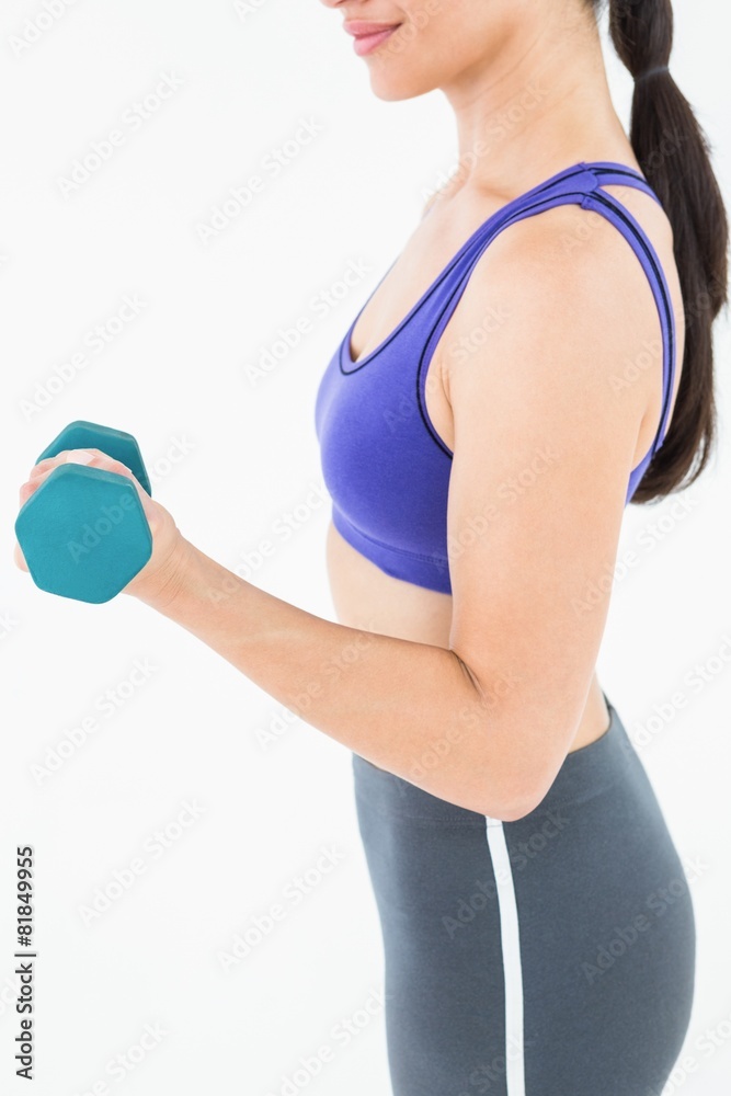 Fit woman lifting dumbbell