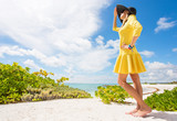 Woman in yellow dress standing on the beach