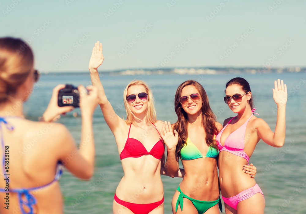 group of smiling women photographing on beach group of smiling women photographing on beach