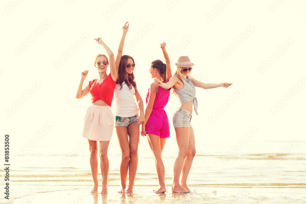 group of smiling women dancing on beach group of smiling women dancing on beach
