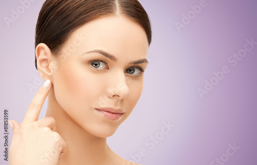 face of beautiful woman touching her ear photo