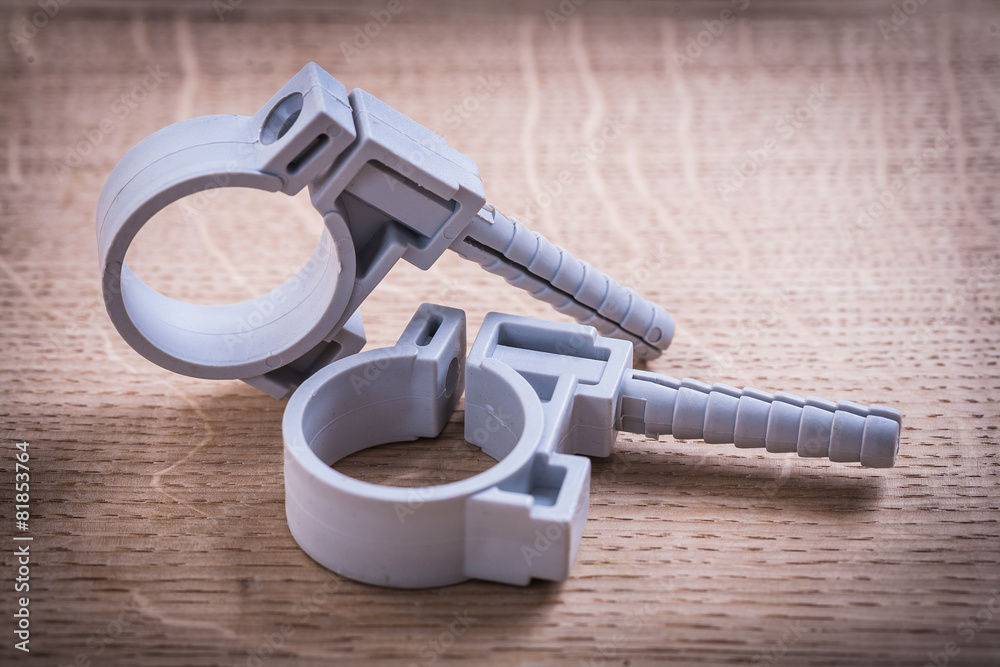 Obraz premium Polypropylene Pipe Fixators On Wooden Board