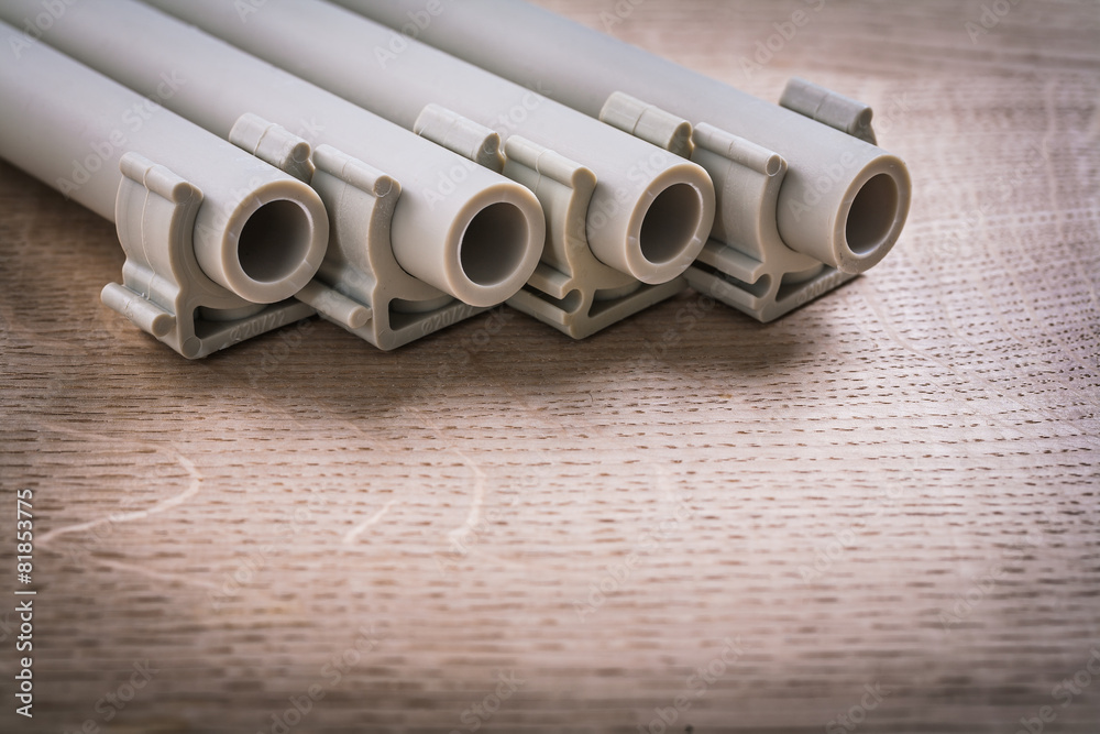 Fototapeta premium Polypropylene Pipe With Clips On Wooden Board