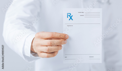 male doctor holding rx paper in hand photo