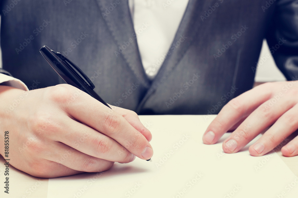 Closeup of businessman hand writing on a paper