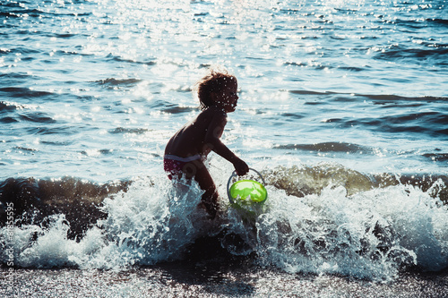 bambina a divertirsi al mare photo