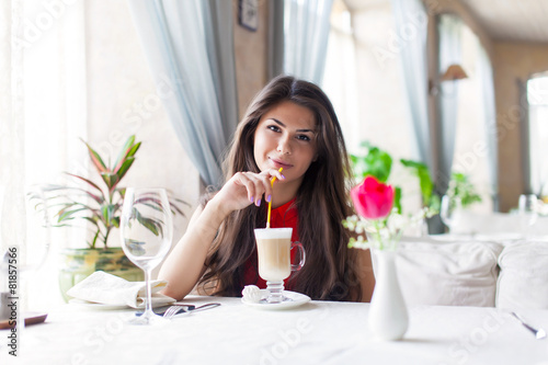 A woman in a restaurant is drinking cocktail photo