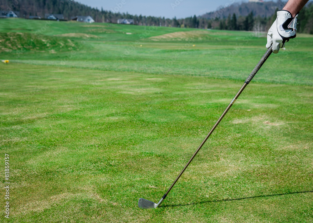 Obraz premium A hand is holding a golf club and measuring the Trajectory. Gree