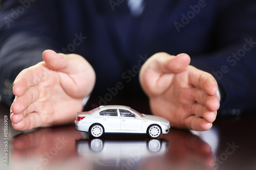 Man and model of car on wooden table, closeup