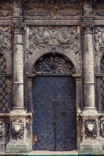 Black metal doors and two pillars on each side in a church photo