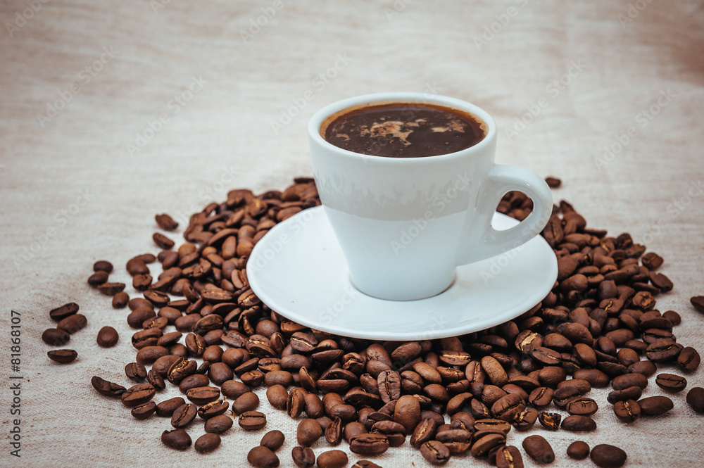 Cup of coffee and roasted beans on beige background Cup of coffee and roasted beans on beige background
