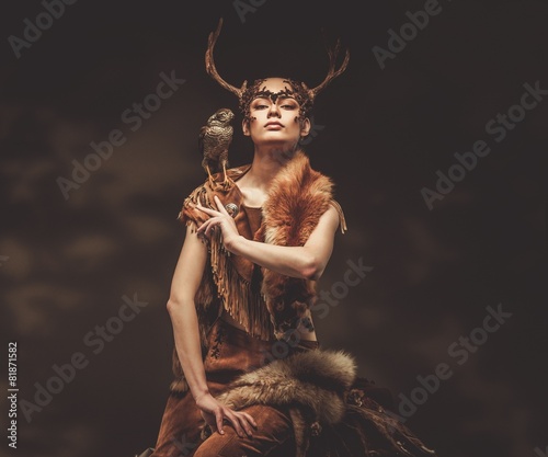 Leinwand Poster Woman shaman in ritual garment with hawk