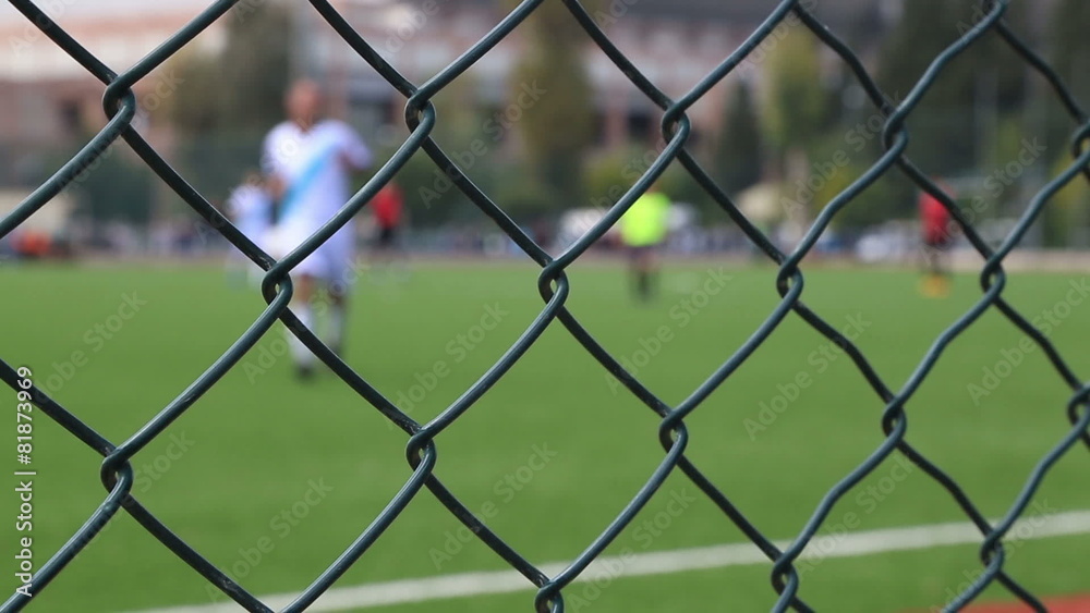 Football match behind the fence Football match behind the fence