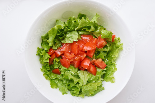 Healthy green salad, tomatoes in white bowl