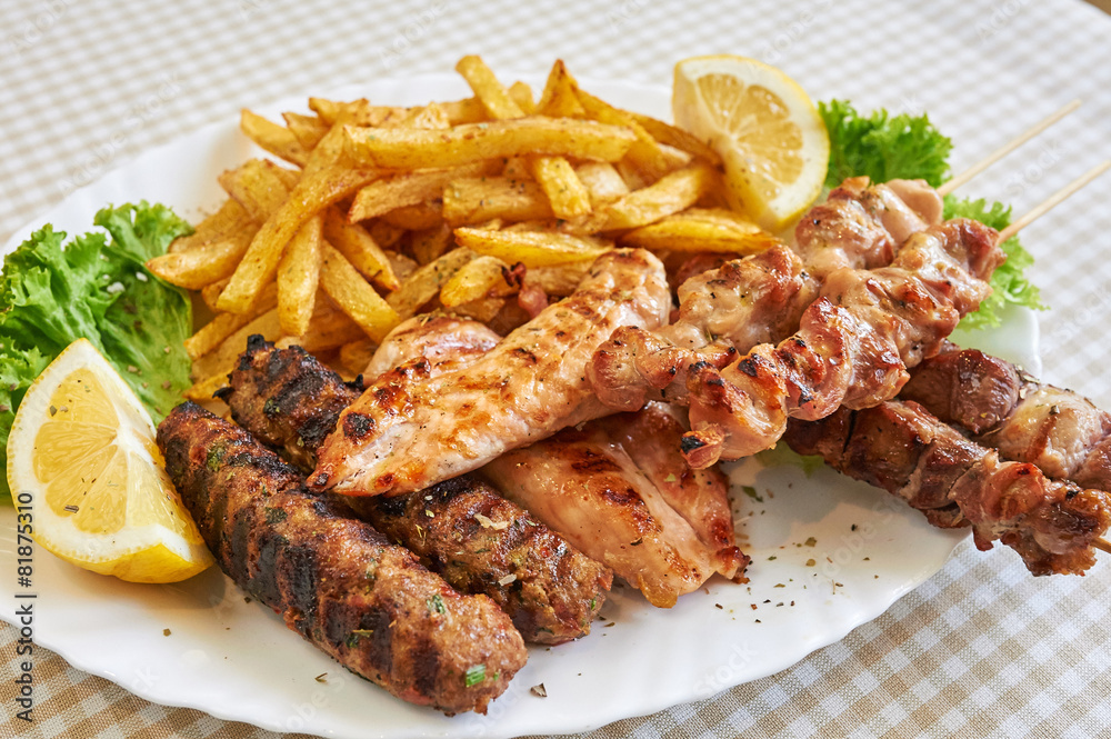 Assort of Grilled sausages with fries and vegetables, barbecue