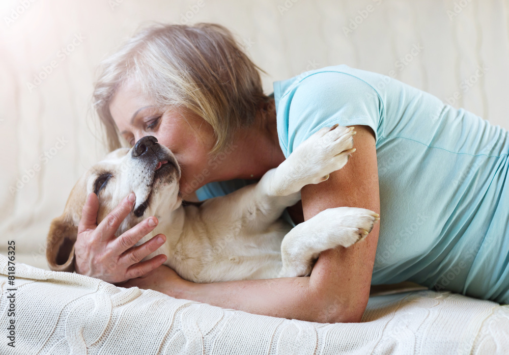 Senior woman with her dog on couch inside of her house Senior woman with her dog on couch inside of her house