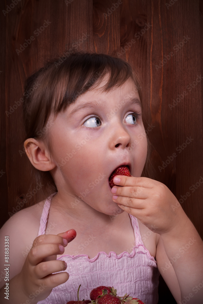 Little girl eating strawberries at home Little girl eating strawberries at home