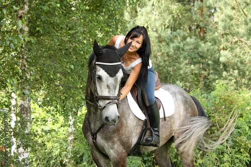 Beautiful woman and gray horse portrait in garden