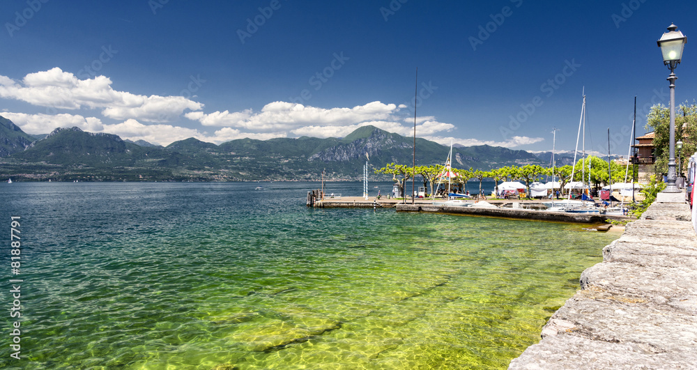 High mountains and sailing boat on the Lake Garda